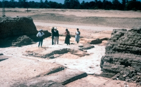 Architectural survey: In 1987 the project began a survey of previously excavated buildings, starting with the Small Aten Temple. Here the foundations of the doorway between the outermost brick pylons have been exposed. Originally floored with stones, with a low platform in the centre, what survives is a thick foundation layer of gypsum which preserves the clear imprint of the individual stones. Architect Michael Mallinson stands in the centre of the group.